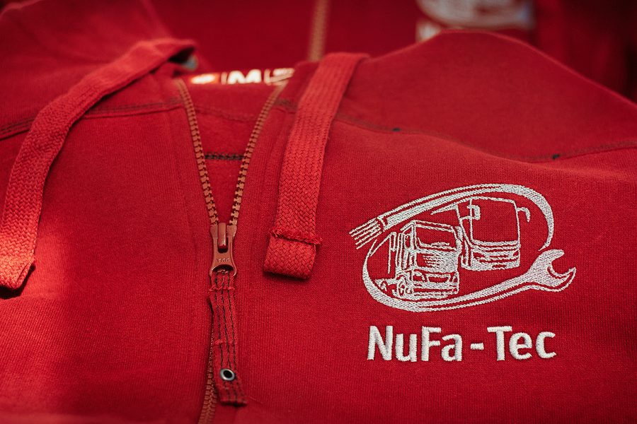 Rote Kapuzenjacke mit gesticktem NuFa-Tec Logo mit Lkw- und Bus-Motiv