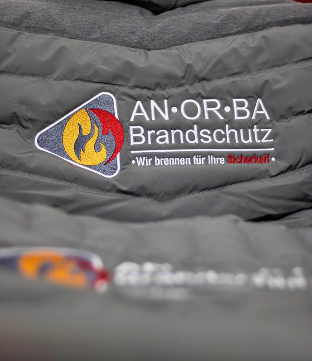 Nahaufnahme einer R&uuml;ckenstickerei mit Logo und Schriftzug