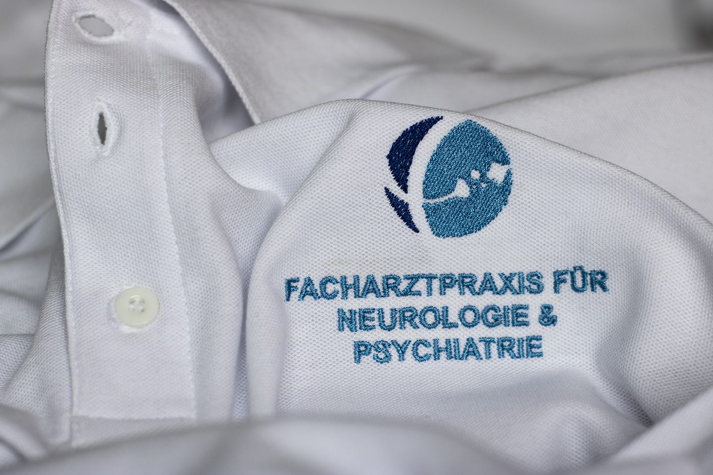 Weißes Polo mit blau gesticktem Logo Facharztpraxis für Neurologie & Psychiatrie